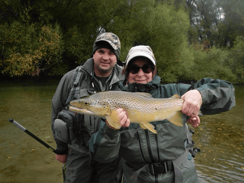 Couple holding a large brown trout during a guided fly fishing trip on the Mataura River, New Zealand